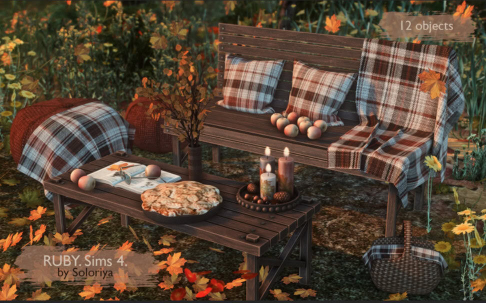 Cozy outdoor Thanksgiving scene with plaid cushions and candles, autumn leaves, and rustic furniture, perfect for Sims 4 Must Have Mods.